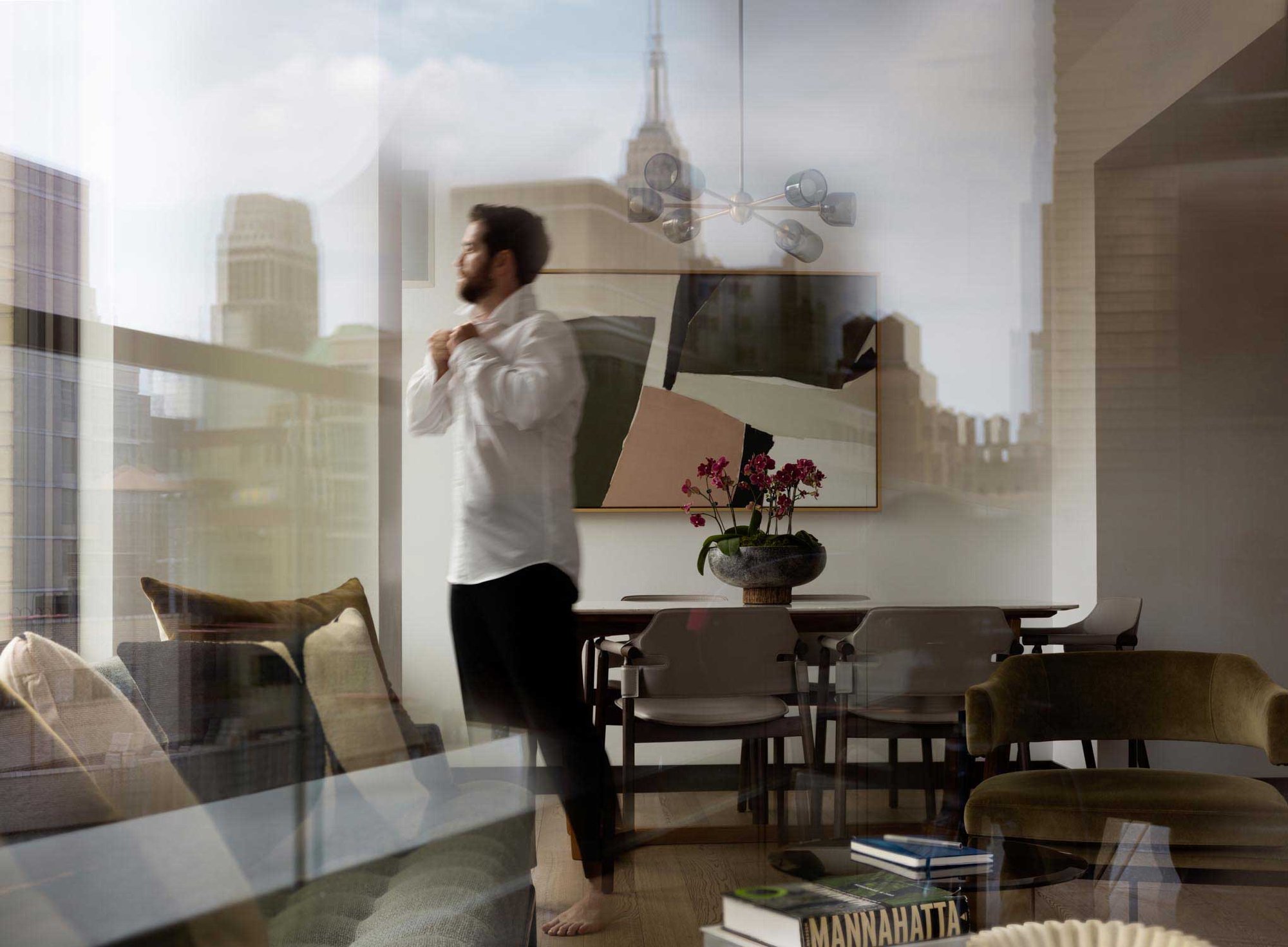 Guest relaxing at Arlo Midtown hotel room with city skyline views in New York City