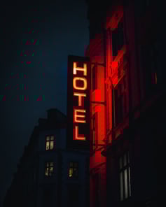 Hotel sign lights up in the dark resembling how hotels try to show up in the crowded competition using the latest hotel advertising trends. 