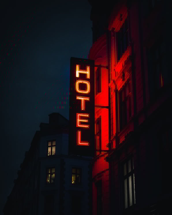 Hotel sign lights up in the dark resembling how hotels try to show up in the crowded competition using the latest hotel advertising trends. 