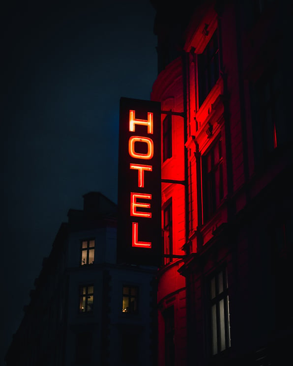 Hotel sign lights up in the dark resembling how hotels try to show up in the crowded competition using the latest hotel advertising trends. 