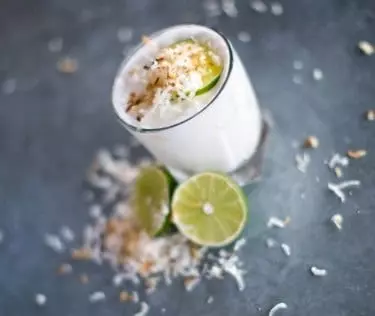 Clear drinking glass with white liquid and sliced lemon