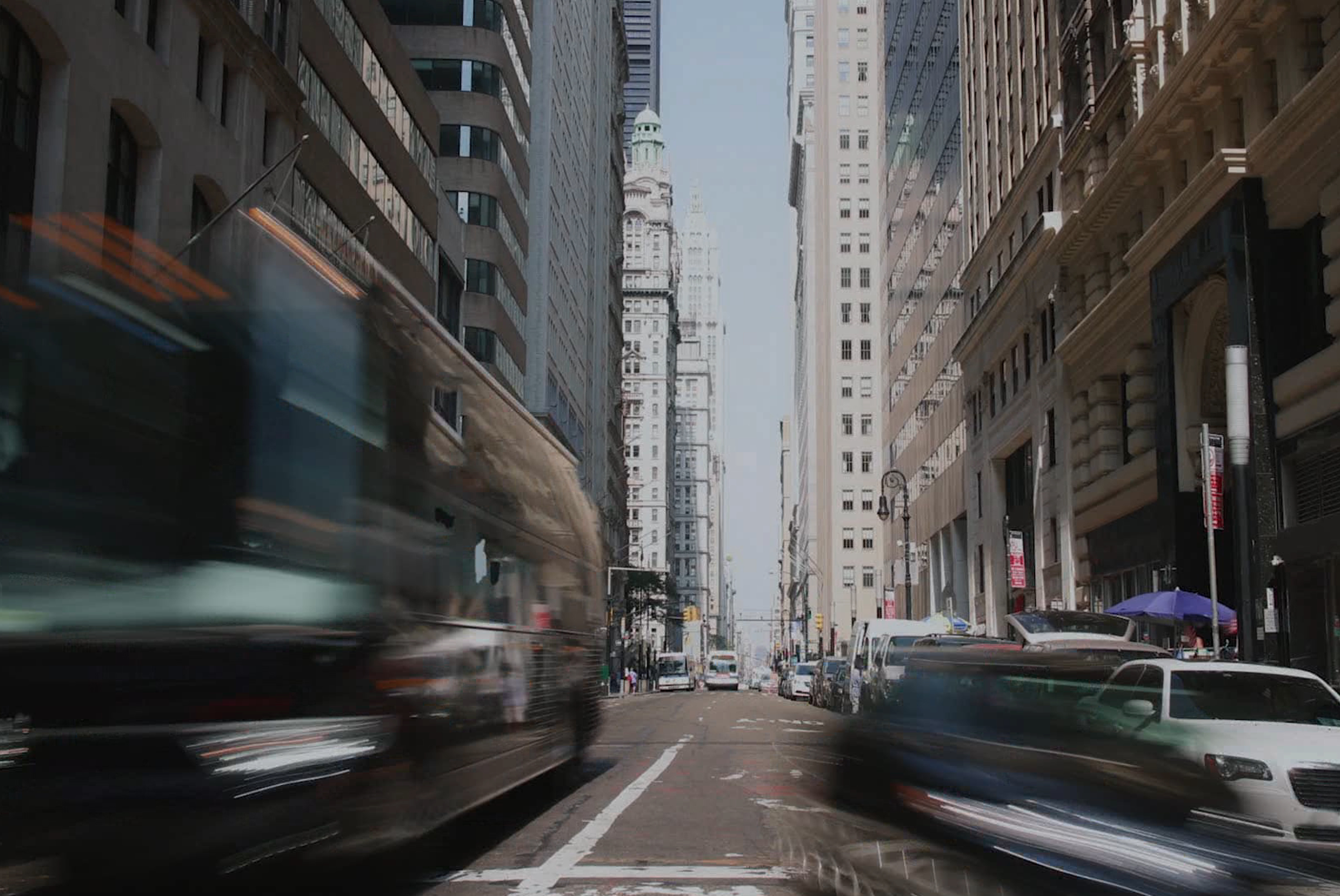 Cars on road between high rise buildings during daytime